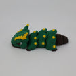 Green and yellow caterpillar-shaped sensory toy with brown accents on a white background