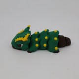 Green and yellow caterpillar-shaped sensory toy with brown accents on a white background
