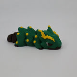 Colorful 3D printed green caterpillar sensory toy with yellow spikes on white background