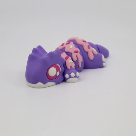 Purple gecko-shaped sensory toy with pink sprinkle-like details, 3D printed, on white background