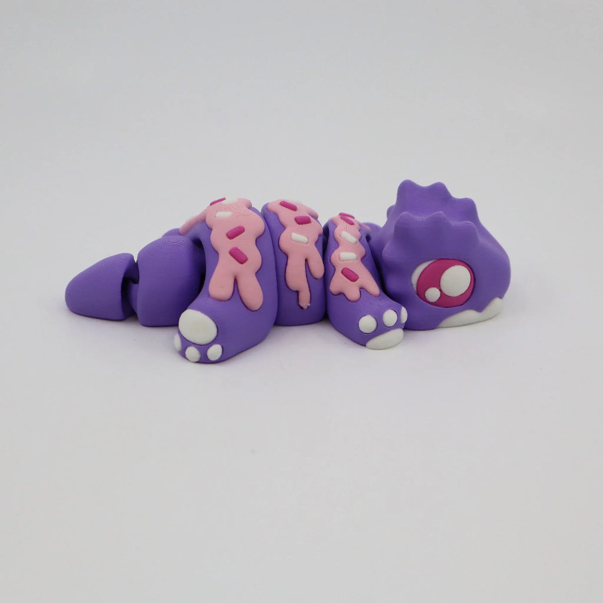 Purple and pink 3D printed sensory caterpillar toy with segmented body on white background
