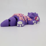 Purple 3D printed sensory toy lizard with pink sprinkle detail on a white background