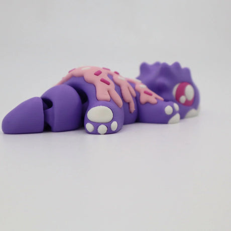 Purple 3D printed sensory toy lizard with pink sprinkle detail on a white background