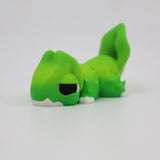 Green 3D printed sensory toy dinosaur lying down on a white background