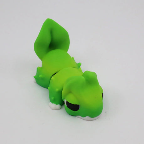 Green 3D printed sensory toy lizard with white feet on a plain background