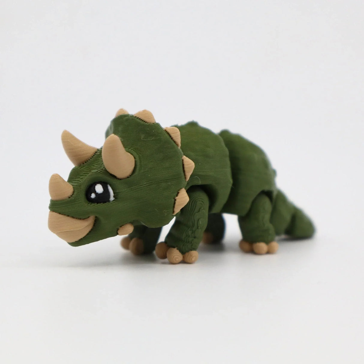 Green 3D printed flexible triceratops dinosaur sensory toy on a white background
