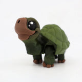 3D printed green turtle sensory toy with big eyes on a white background