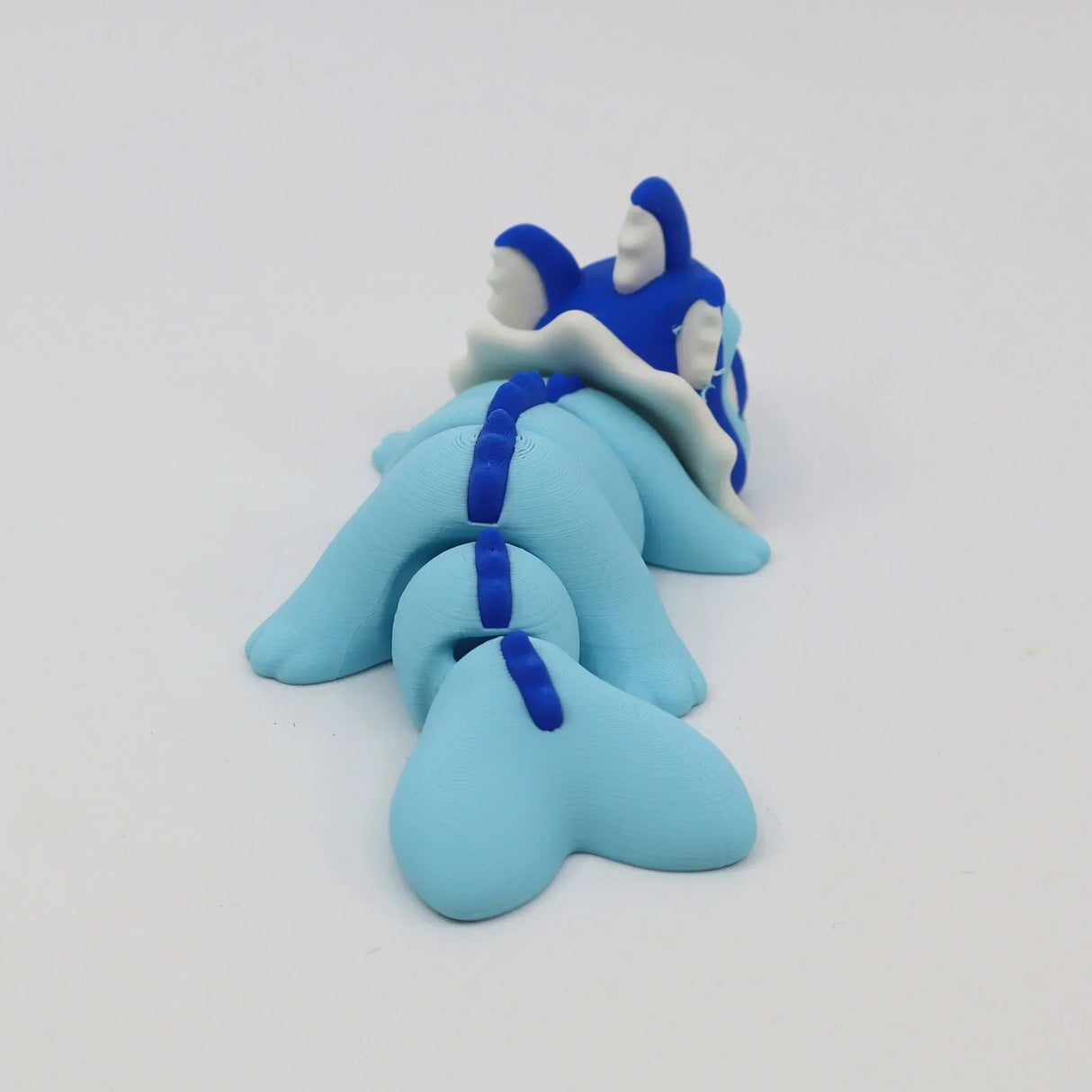 Blue 3D printed sensory toy resembling a segmented dragon or sea creature on white background