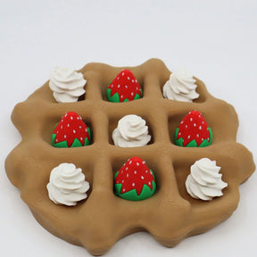 3D printed waffle sensory toy with strawberry and whipped cream pieces on a white background