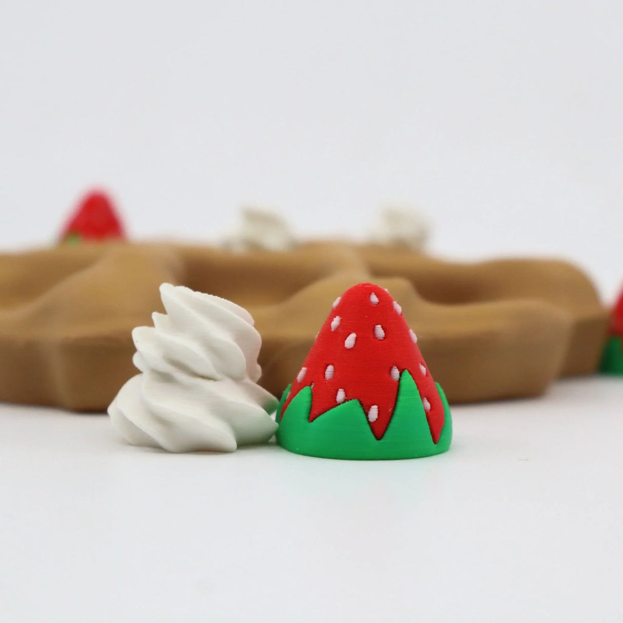 3D printed sensory toy shaped like a waffle with strawberry and whipped cream pieces