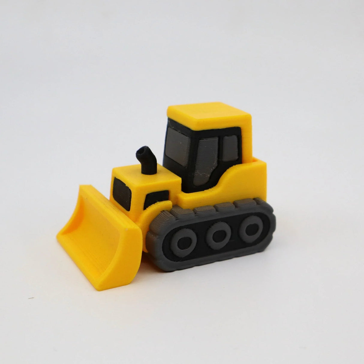 Yellow and gray 3D printed bulldozer sensory toy for children on white background