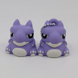 Two purple 3D printed warthog sensory toys with white accents and a keychain on one
