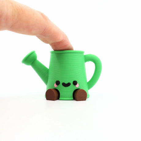 Adorable green 3D printed watering can fidget toy with cute face, perfect for sensory play and stress relief.