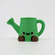 Green 3D printed watering can fidget toy with cute face and brown feet for sensory play