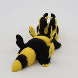 Yellow and black 3D printed segmented sensory toy animal on white background